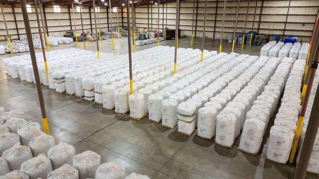 Rows of white bulk bags stored on a warehouse floor