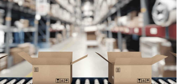 Two open cardboard boxes on a roller conveyor with blurred warehouse racking behind