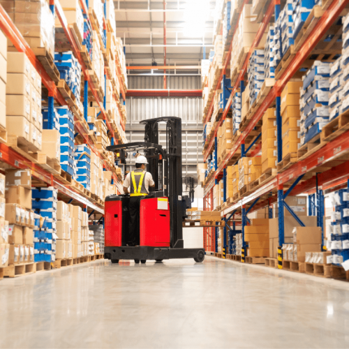 Worker drives three-wheel forklift between rows of warehousing racking in Ontario
