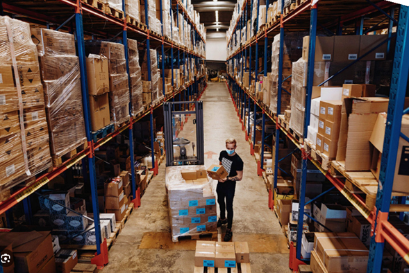 Tall pallet racking lining a dimly lit warehouse aisle