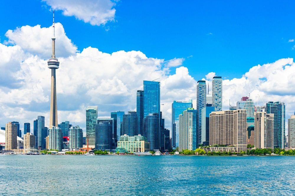 Toronto skyline with the CN Tower seen across the water under a bright cloudy sky